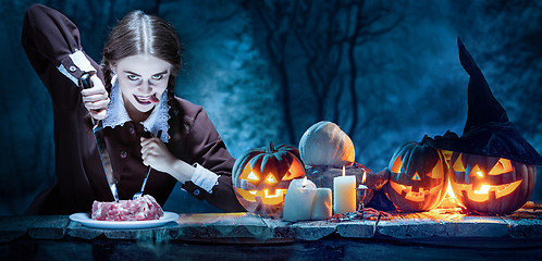 Image showing Bloody Halloween theme: crazy girl with a knife and meat