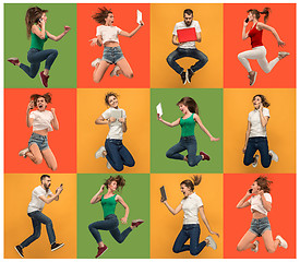 Image showing The happy young jumping women and man with laptops and phone