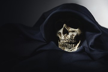 Image showing Closeup photo an old skull covered in black robe