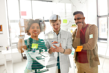 Image showing happy creative team at office glass board