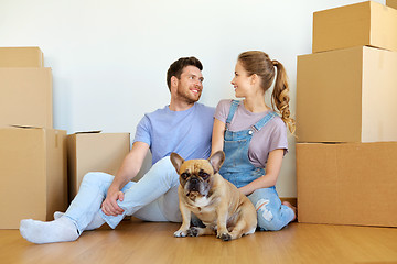 Image showing happy couple with boxes and dog moving to new home