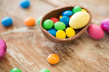 Image showing chocolate easter egg and candy drops on table