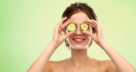 Image showing smiling woman with cucumber over green background