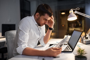 Image showing businessman with papers working at night office