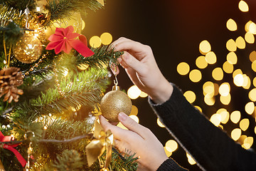 Image showing Girl decorates a Christmas tree 