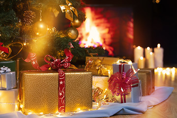 Image showing Christmas presents and candles under Christmas tree