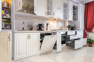 Image showing Luxury modern white kitchen interior with open doors and drawers