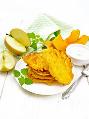 Image showing Pancakes of pumpkin with apple in plate on light wooden board