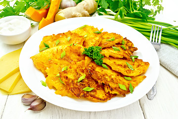 Image showing Pancakes of pumpkin with cheese in plate on wooden board