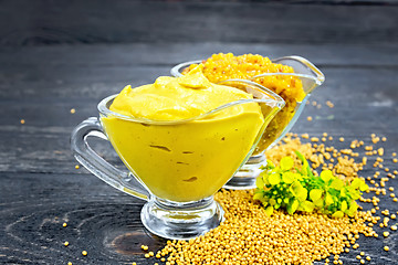 Image showing Sauce mustard in two sauceboats with flower on table