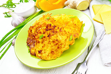 Image showing Pancakes of pumpkin with cheese in green plate on white board