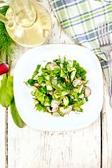 Image showing Salad of radish and sorrel with oil in plate on board top