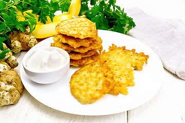 Image showing Pancakes of pumpkin with Jerusalem artichoke on light wooden board