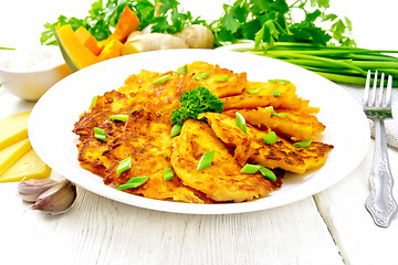 Image showing Pancakes of pumpkin with cheese in white plate on board