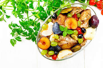 Image showing Chicken with fruits and tomatoes in pan on board top