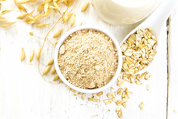 Image showing Flour oat in bowl with milk on light board top