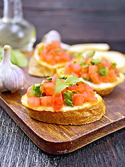 Image showing Bruschetta with tomato and spinach on dark board
