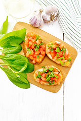 Image showing Bruschetta with tomato and spinach on white board top