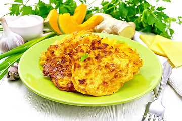 Image showing Pancakes of pumpkin with cheese in green plate on board