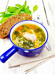 Image showing Soup with couscous and spinach in blue bowl on towel
