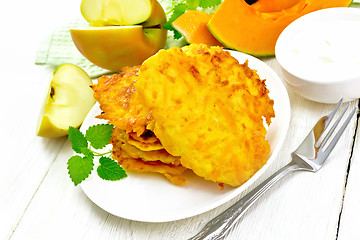 Image showing Pancakes of pumpkin with apple in plate on board