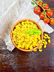 Image showing Elbow macaroni in bowl with tomatoes on board top