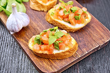 Image showing Bruschetta with tomato and spinach on wooden board