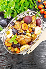 Image showing Chicken with fruits and tomatoes in glass pan on dark board top