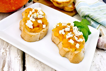 Image showing Bruschetta with pumpkin and cheese in plate on light board