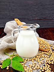 Image showing Milk soy in jug with spoon and leaf on board