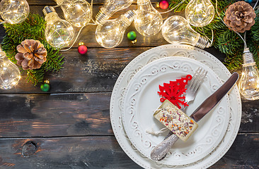 Image showing Christmas table setting with fairy lights and fir tree branches.