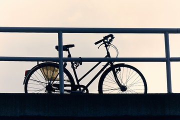 Image showing Bicycle on a street silhouette against dusk sky