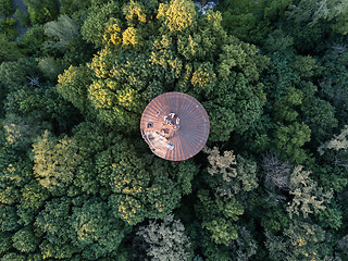 Image showing Top view of a round old roof with people around green trees. Aerial view from the drone