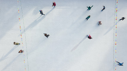 Image showing Outdoor ice skating rink with people riding on a winter day. Aerial view from the drone.