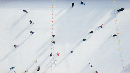 Image showing Aerial view of a drone on an open ice rink with people on a winter sunny day.