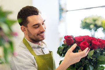 Image showing florist or seller setting red roses at flower shop