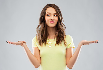 Image showing happy teenage girl holding something imaginary