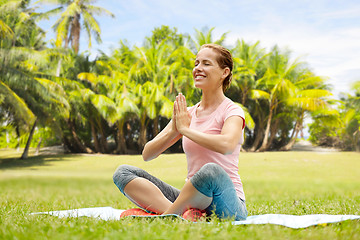 Image showing happy woman meditating in exotic summer park