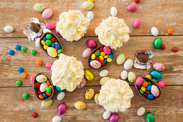 Image showing cupcakes with chocolate eggs and candies on table