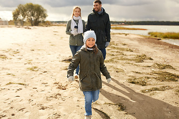 Image showing happy family walking along autumn beach