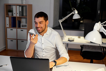 Image showing businessman recording voice message on smartphone