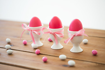 Image showing easter eggs in holders and candy drops on table