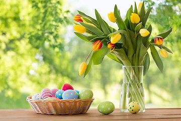 Image showing colored easter eggs in basket and flowers