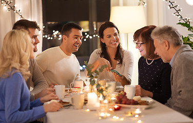 Image showing happy family with smartphone at tea party at home