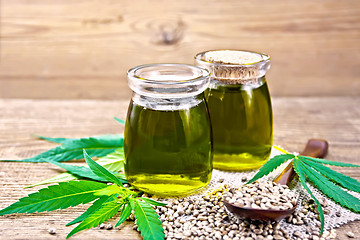 Image showing Oil hemp in two jars and spoon on board