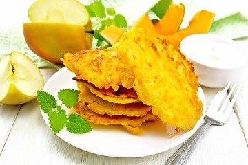 Image showing Pancakes of pumpkin with apple in plate on white board