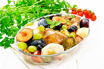 Image showing Chicken with fruits and tomatoes in pan on light wooden board