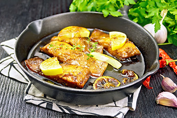 Image showing Salmon with sauce in pan on board