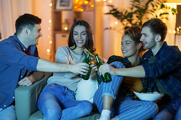 Image showing friends clinking drinks at home in evening