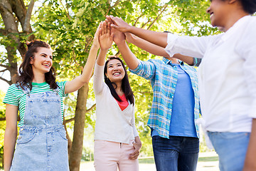 Image showing happy friends making high five in park